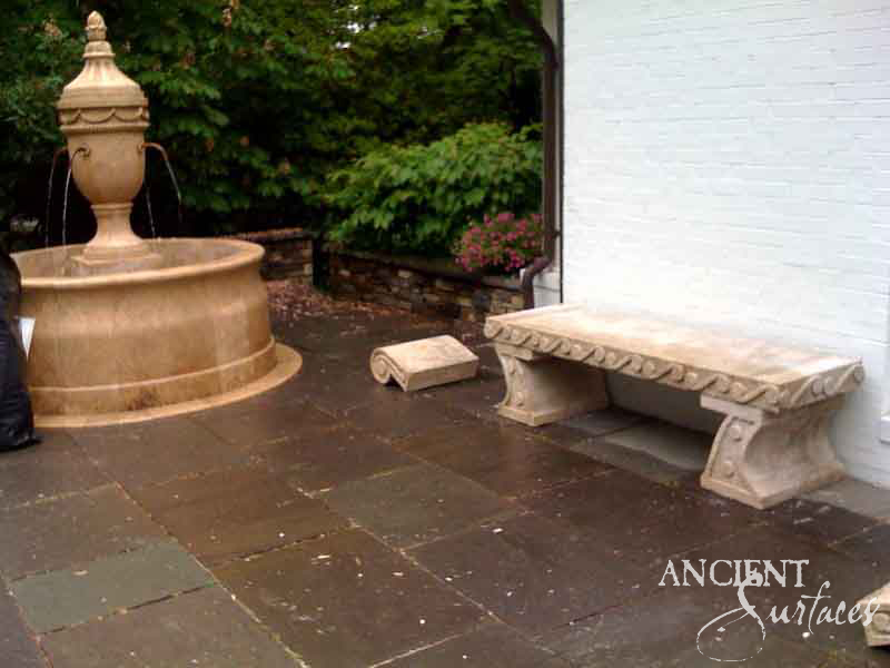 Draped-urn reclaimed limestone pool fountain with paired spouts on a round basin, installed on a stone terrace