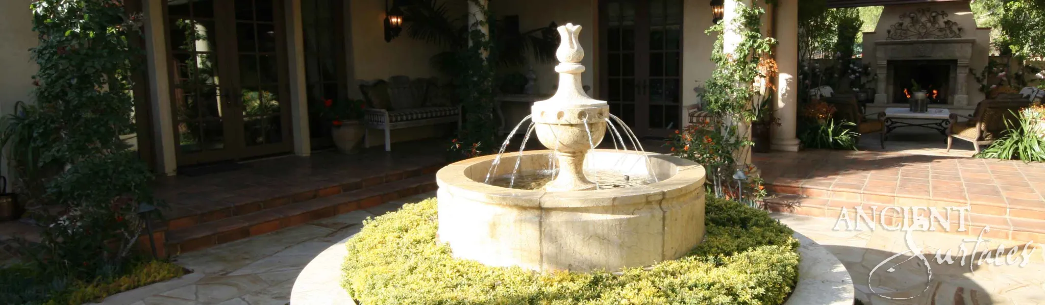 Reclaimed limestone fountain with flowing water at the heart of an elegant Mediterranean courtyard